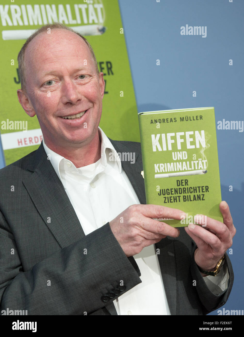 Juvenile court judge Andreas Mueller poses with his book entitled 'Kiffen und Kriminalitaet - Der Jugendrichter zieht Bilanz' (lit. Smoking weed and crime - A juvenile court judge takes stock) in Berlin, Germany, 11 September 2015. Photo: Joerg Carstensen/dpa Stock Photo