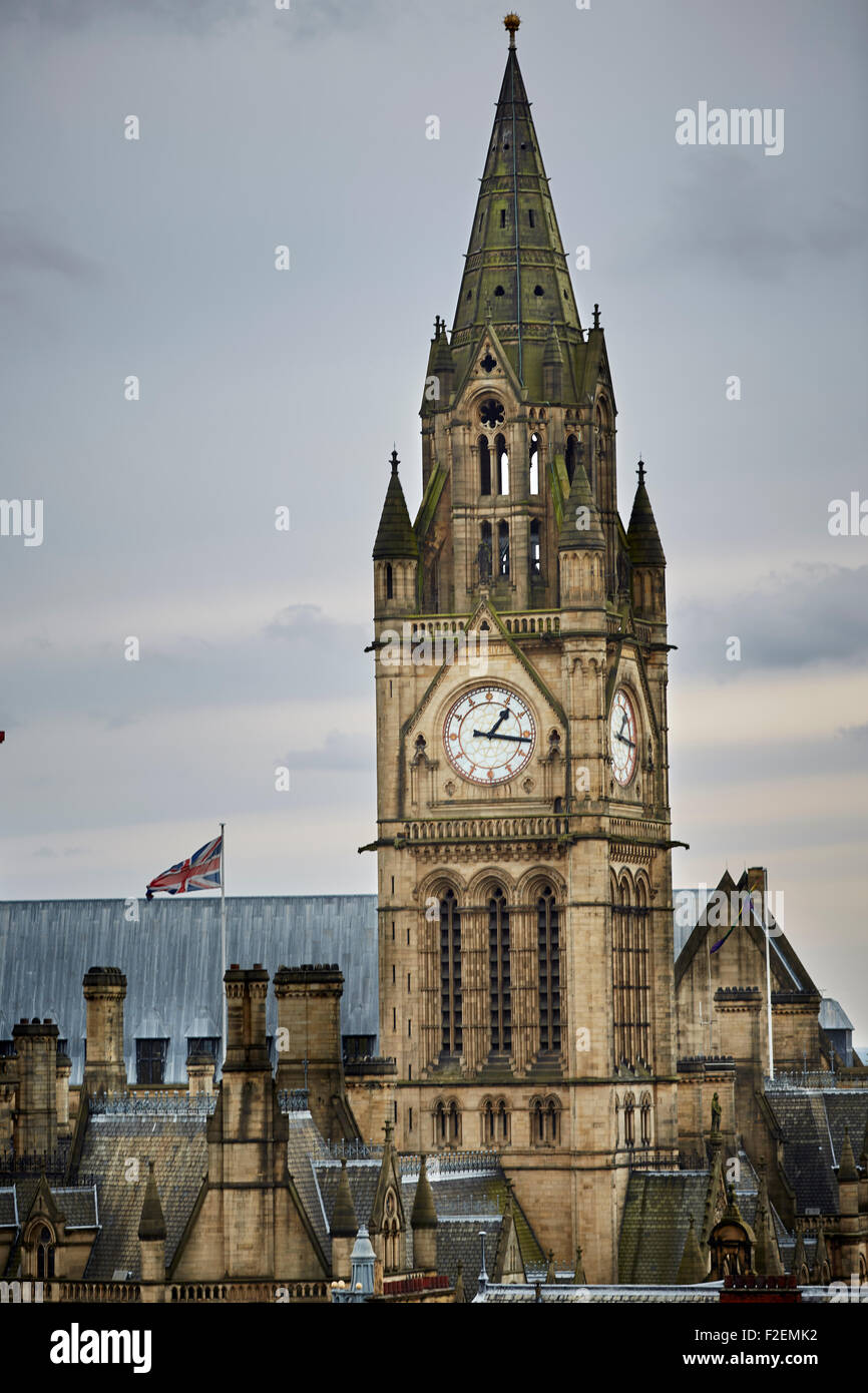 Manchester Town hall clock tower close up over the rooftops clock face union flag flying upright copyspace upright   Manchester Stock Photo