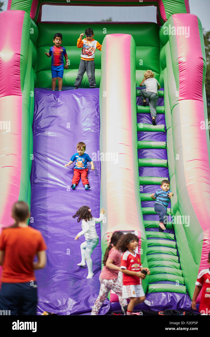 Park Lives at Alexandra Park in Moss Side Manchester community fun day   Pictured free inflatable slide ride Young kids children Stock Photo