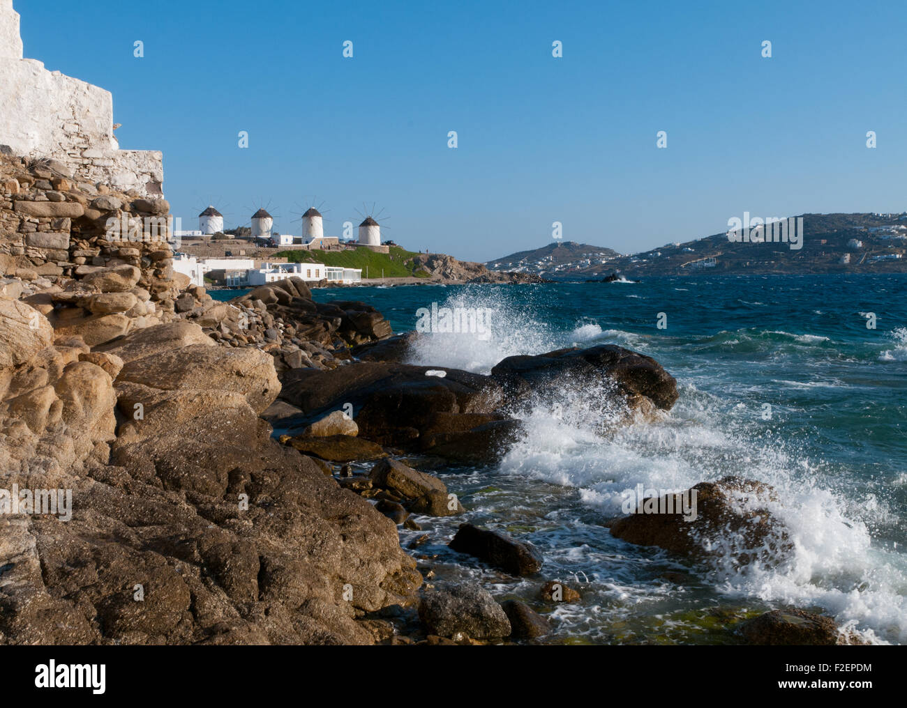 Waves breaking on rocky shore of Greek island of Mykonos, Cyclades Stock Photo