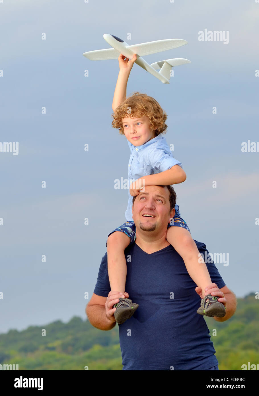 Father carrying son and his plane on shoulders Stock Photo