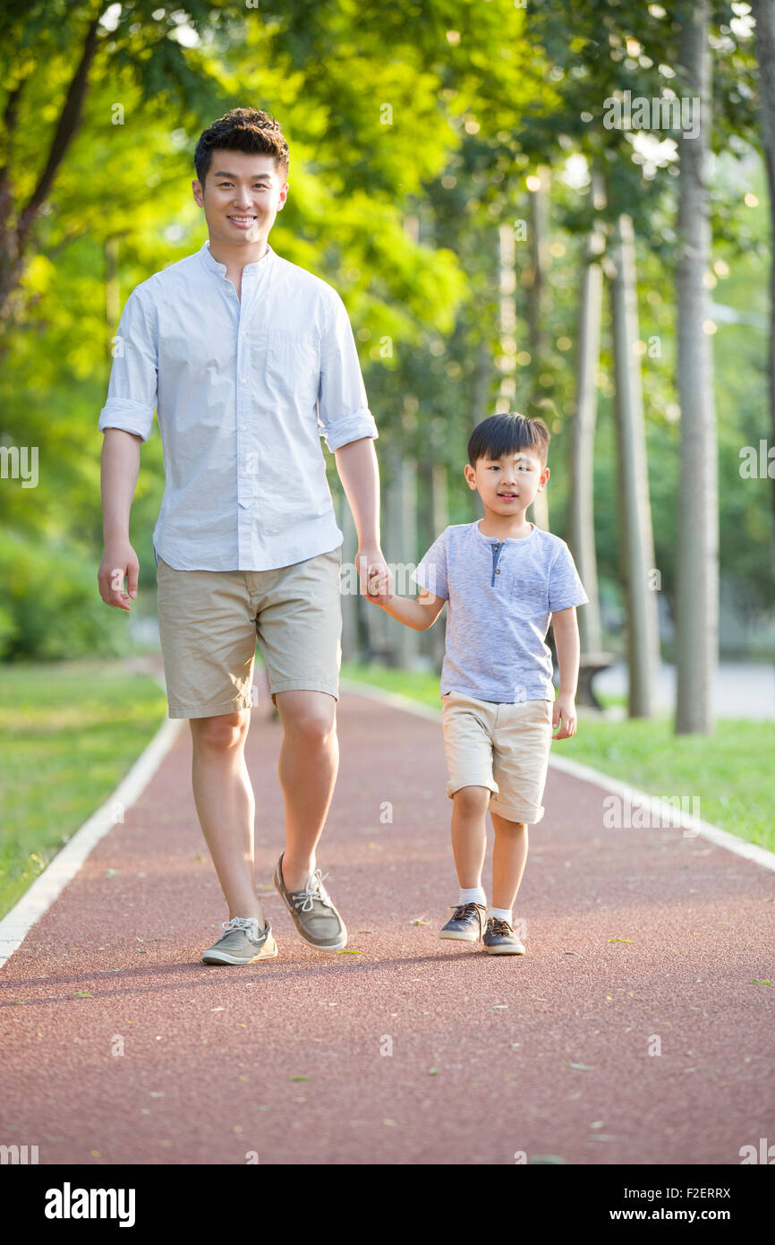 Father and son walking together in park Stock Photo - Alamy