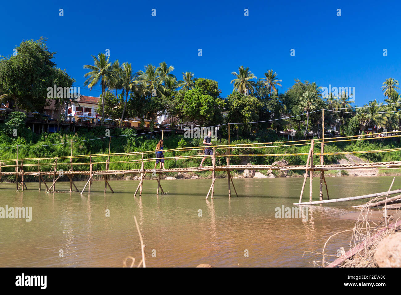 Tourists on bridge across Nam Khan river, Luang Prabang, Laos Stock Photo