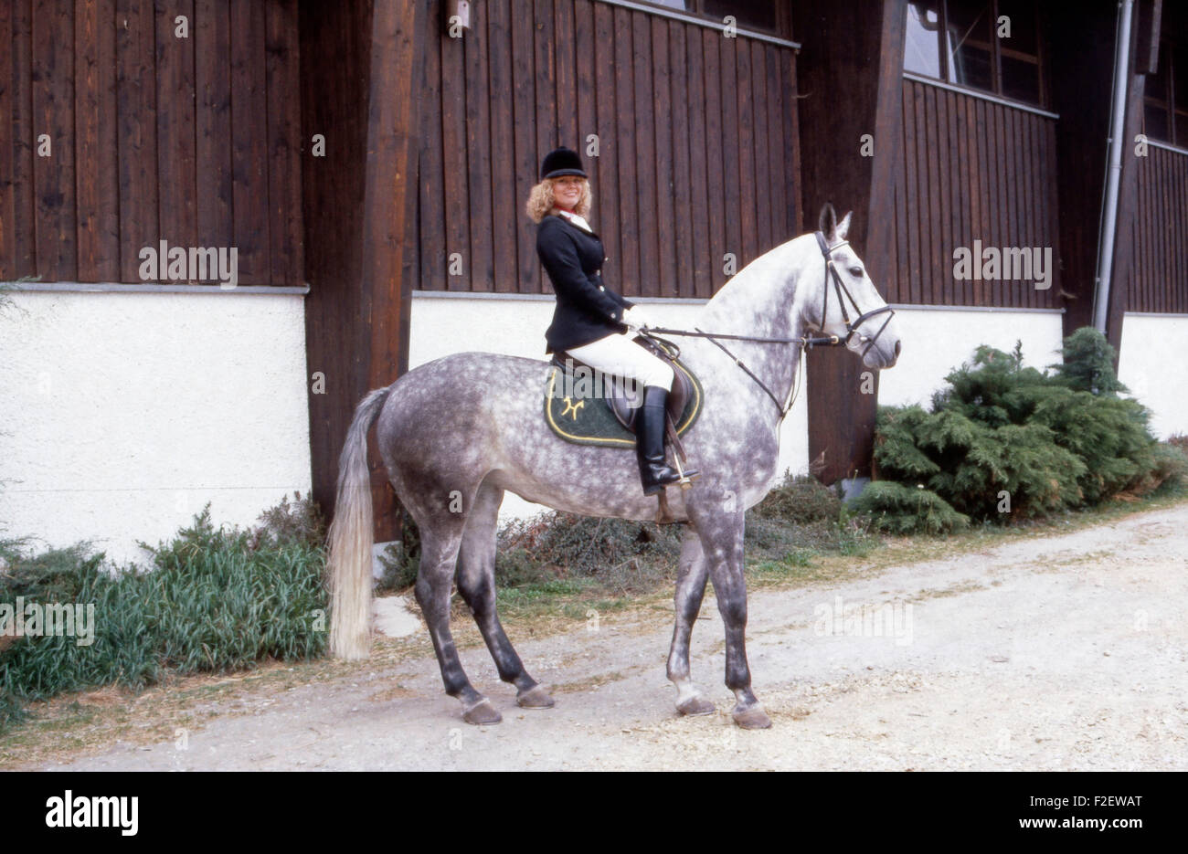 Deutsche Schauspielerin Christiane Rücker bei einer Reitstunde mit Stute Jasmin, Deutschland 1980er Jahre. German actress Christiane Ruecker gets a lesson in horseriding with mare Jasmin, Germany 1980s. 24x36Dia204 Stock Photo