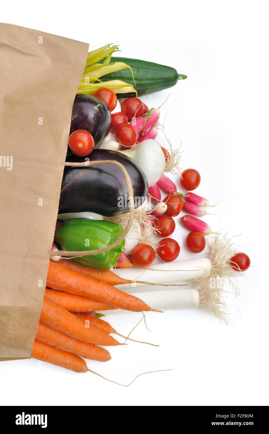 Outgoing fresh vegetables of a paper bag of groceries on white background Stock Photo