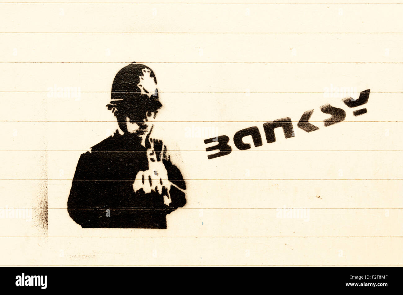 A Banksy graffiti of a policeman and signature on a wall in Lewisham, South London. Stock Photo