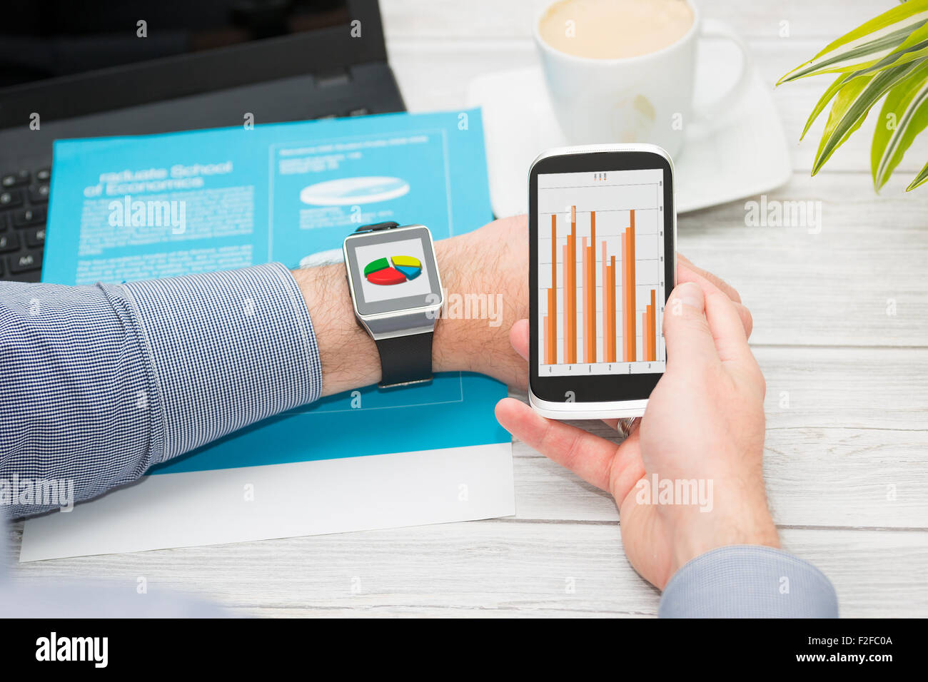 Businessman uses smart watch and phone. Smartwatch concept. Stock Photo