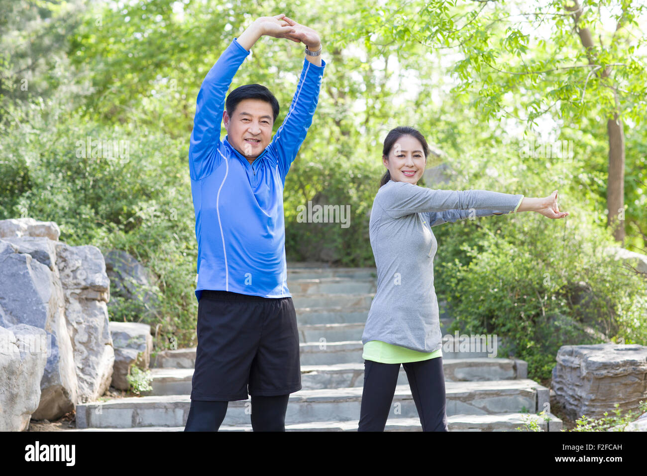 Happy mature couple exercising in park Stock Photo - Alamy