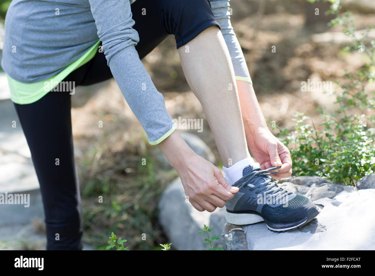 View of Mature woman tying her shoelaces Stock Photo - Alamy