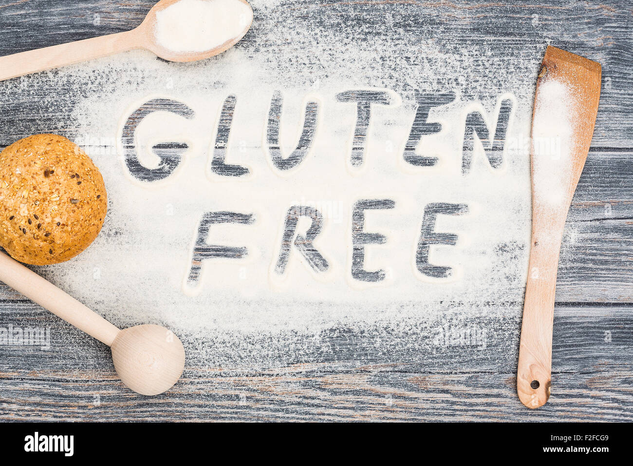 Gluten free word written on flour. Table wooden background. Stock Photo