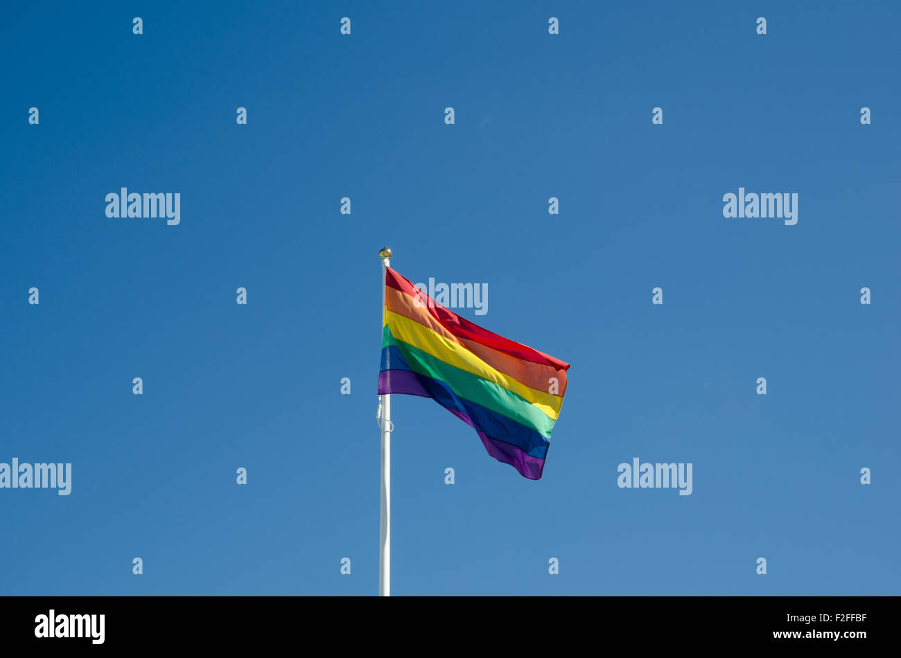 Waving rainbow flag at a clear blue sky Stock Photo