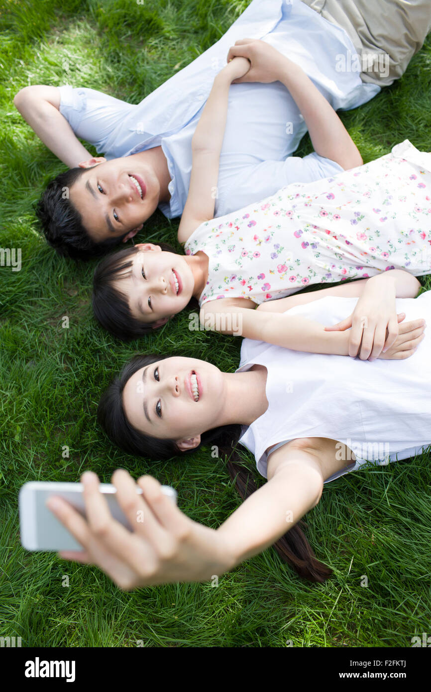 Happy young family lying on grass Stock Photo - Alamy