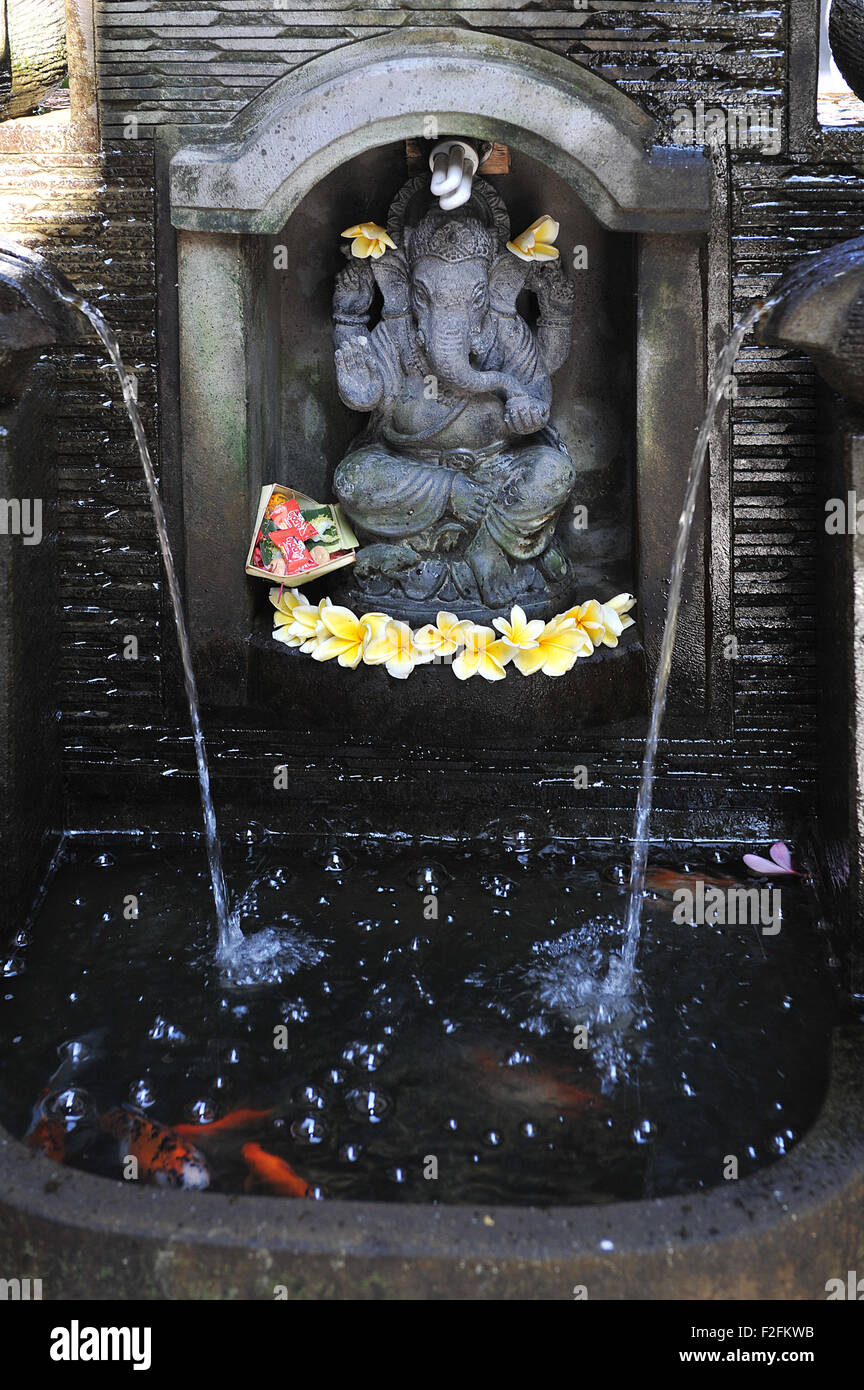 Ganesha statue with a little fish pond, in Monkey forest street, Ubud , bali Stock Photo
