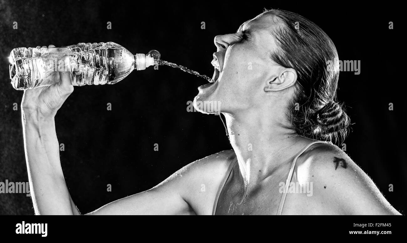 Thirsty Sporty Woman Drinking Water from a Bottle Stock Photo