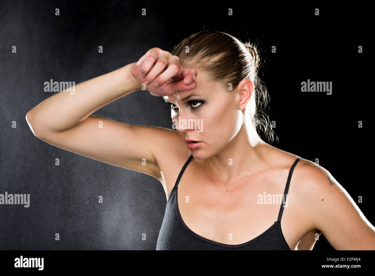Thoughtful Athletic Woman with Hand on Forehead Stock Photo