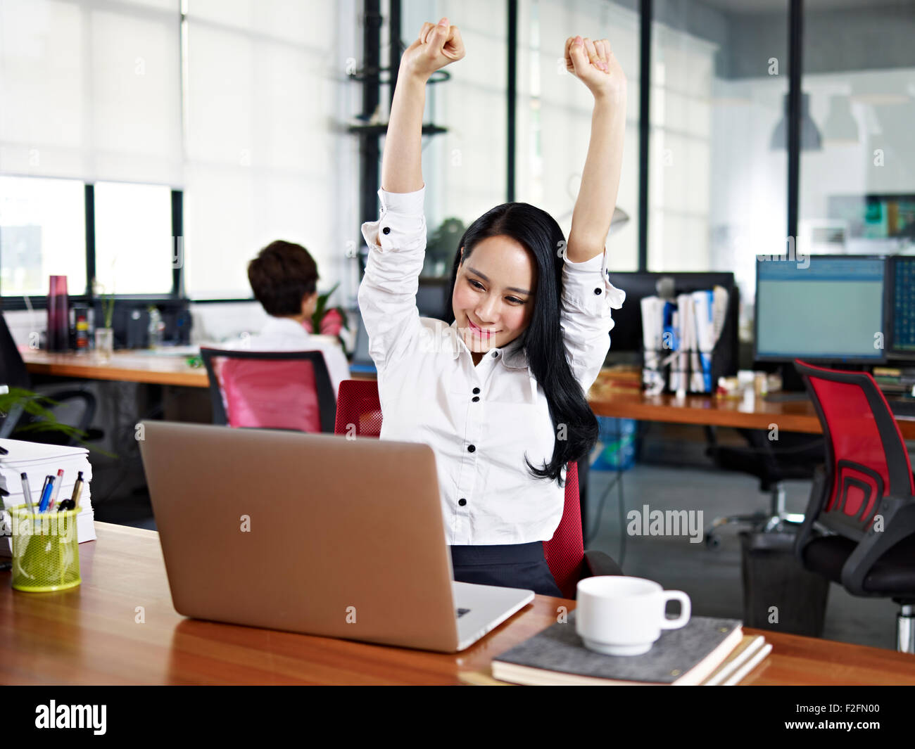 young asian business woman celebrating completion of task Stock Photo