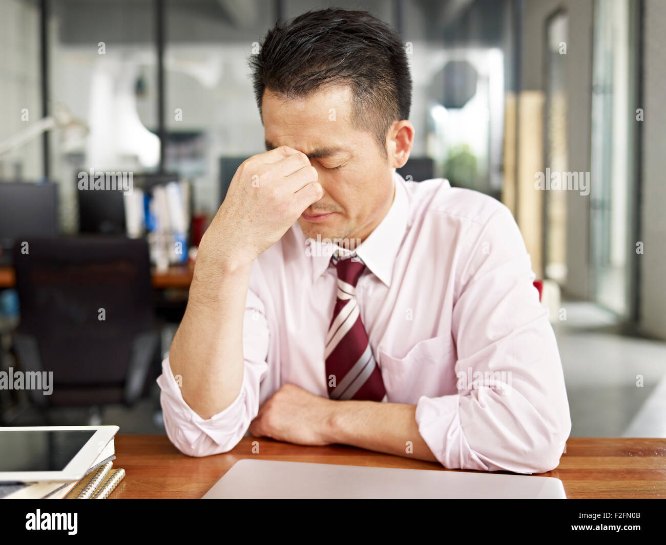 asian businessman looking tired and frustrated Stock Photo