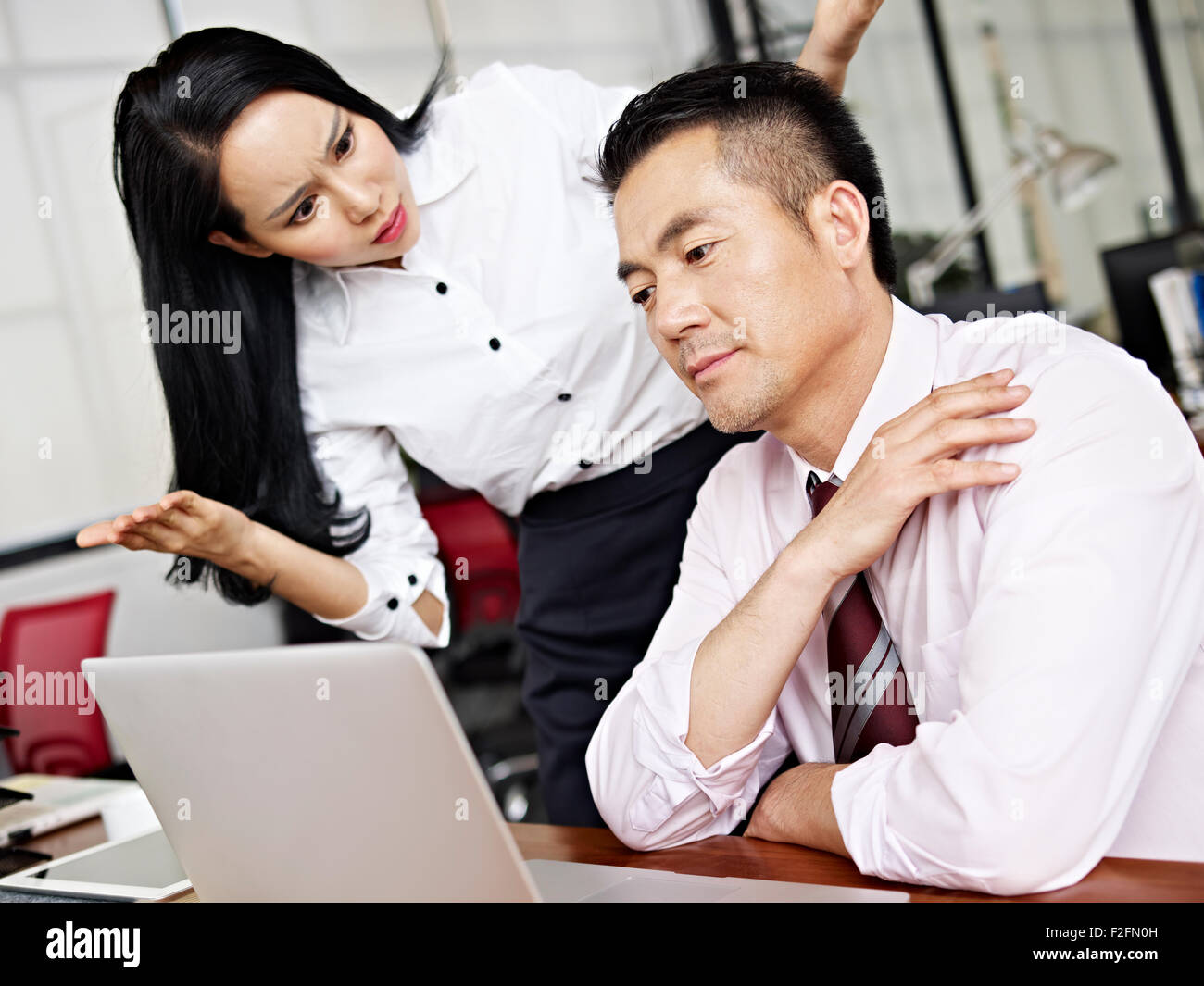 asian businesswoman reacting to male colleague's behavior Stock Photo