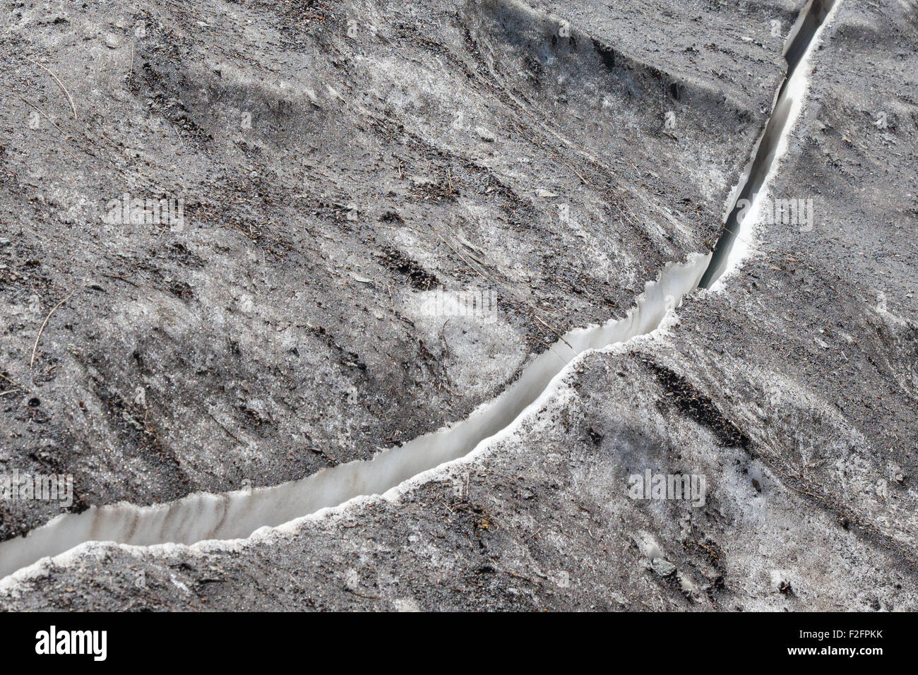 Crack in the ice covered with dirty snow Stock Photo Alamy