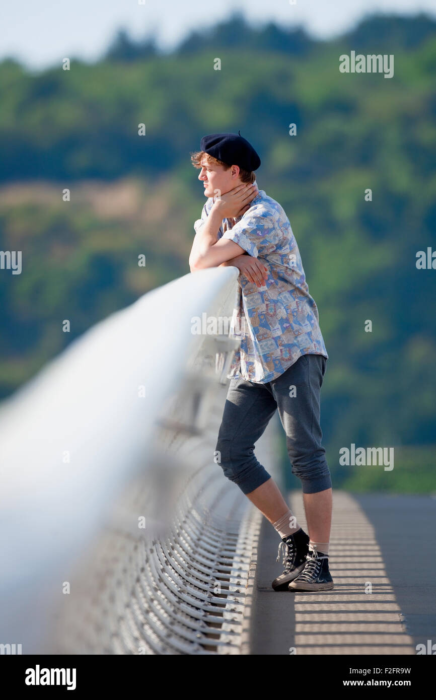 Young Man Standing on the Bridge Looking Down Stock Photo