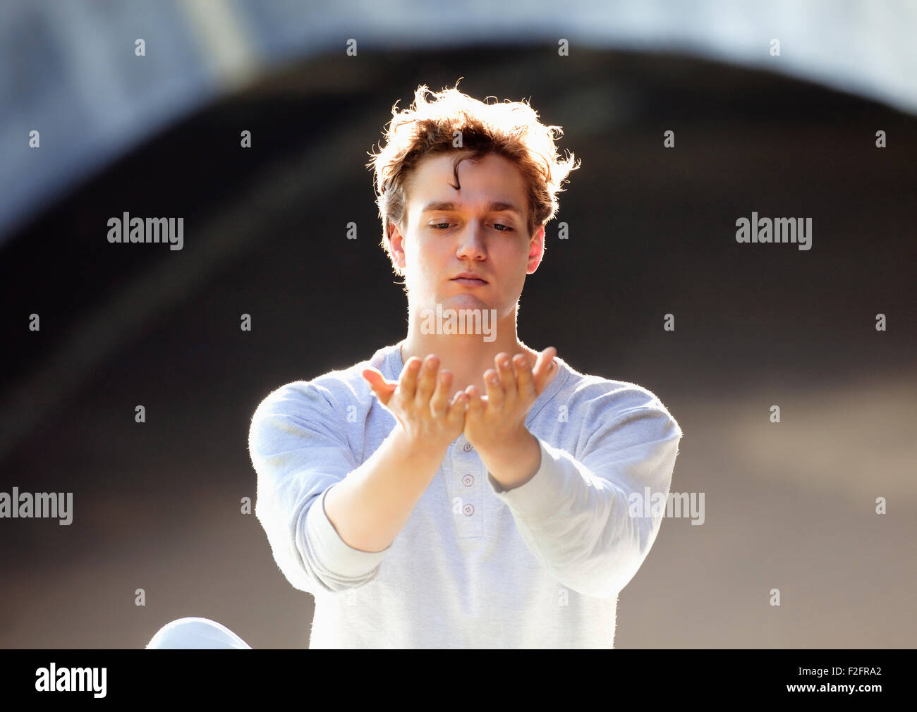 Portrait of a Young Man Exercising Yoga Outdoors. Stock Photo