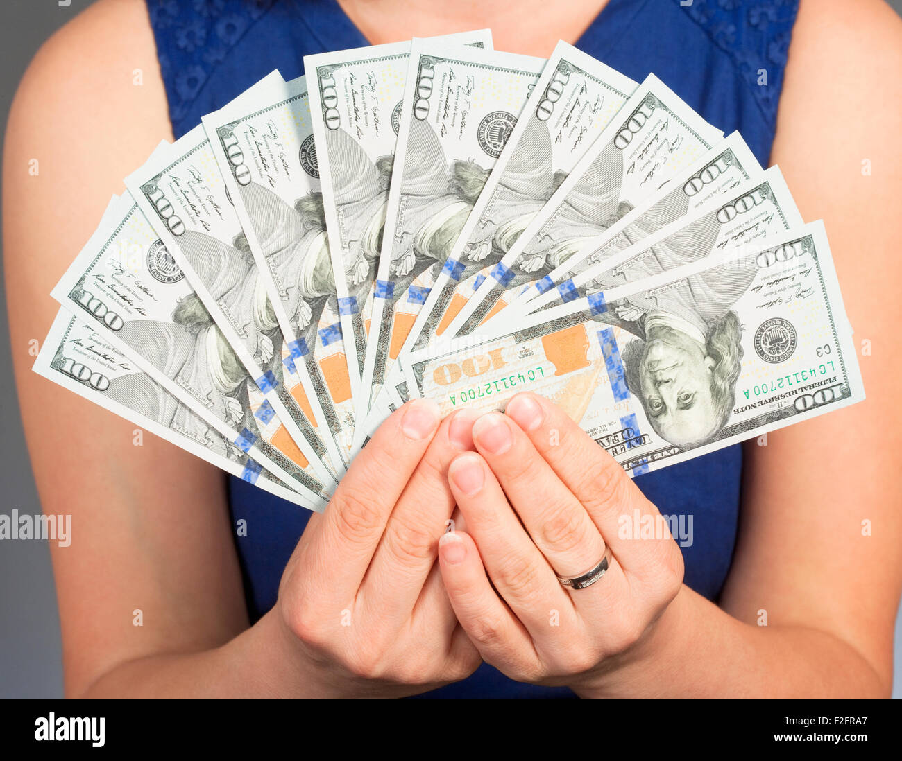 Woman in Blue Dress Holding New 100 US Dollar Bills Stock Photo