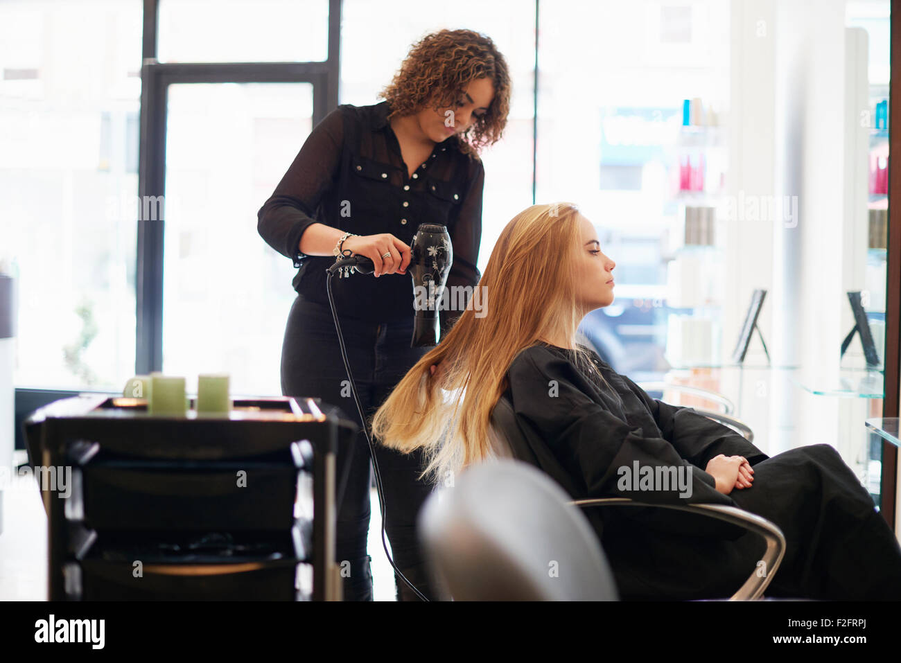 Hairdresser drying customer’s long hair in salon Stock Photo - Alamy