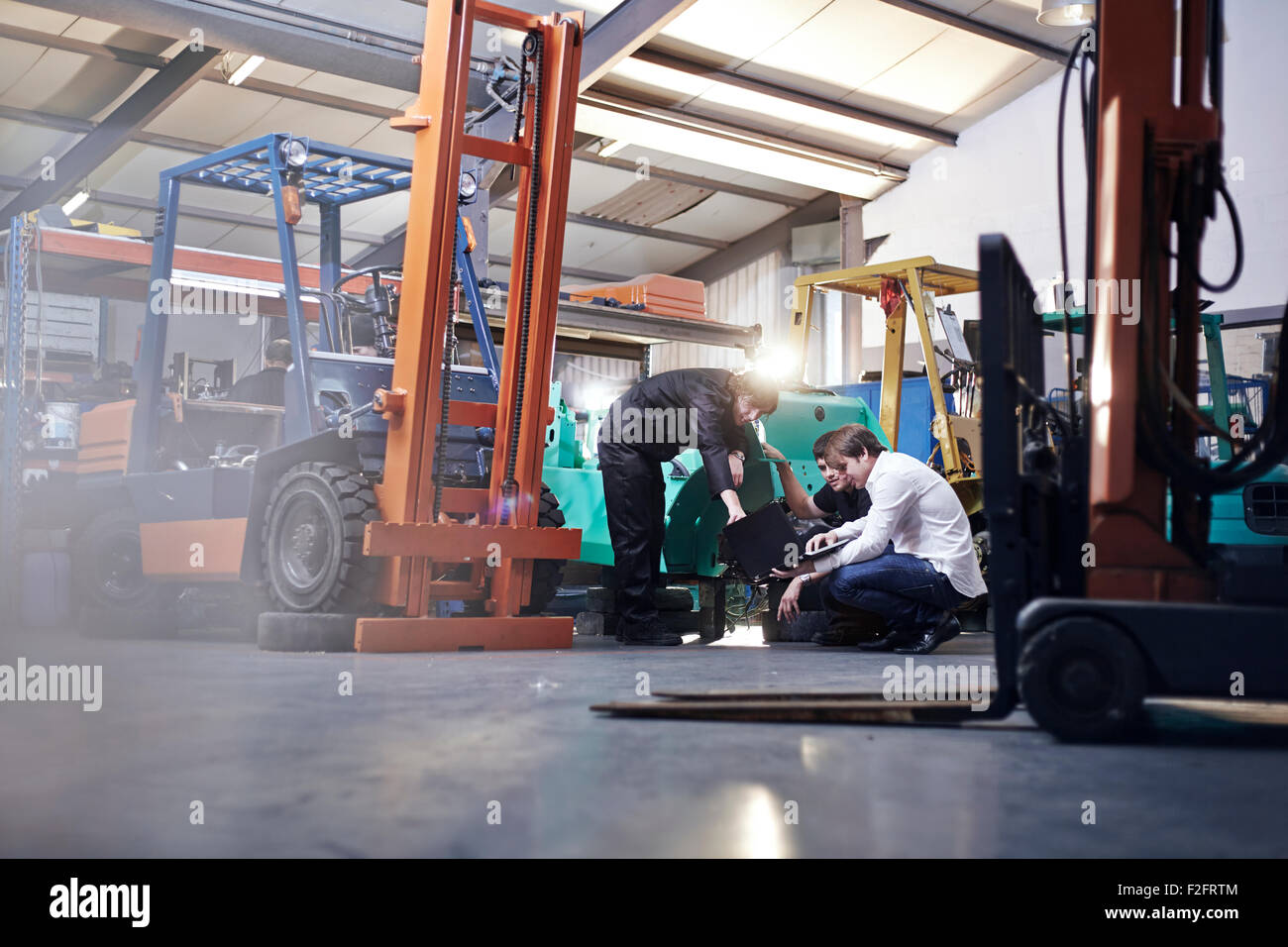 Mechanics working near forklift in auto repair shop Stock Photo Alamy
