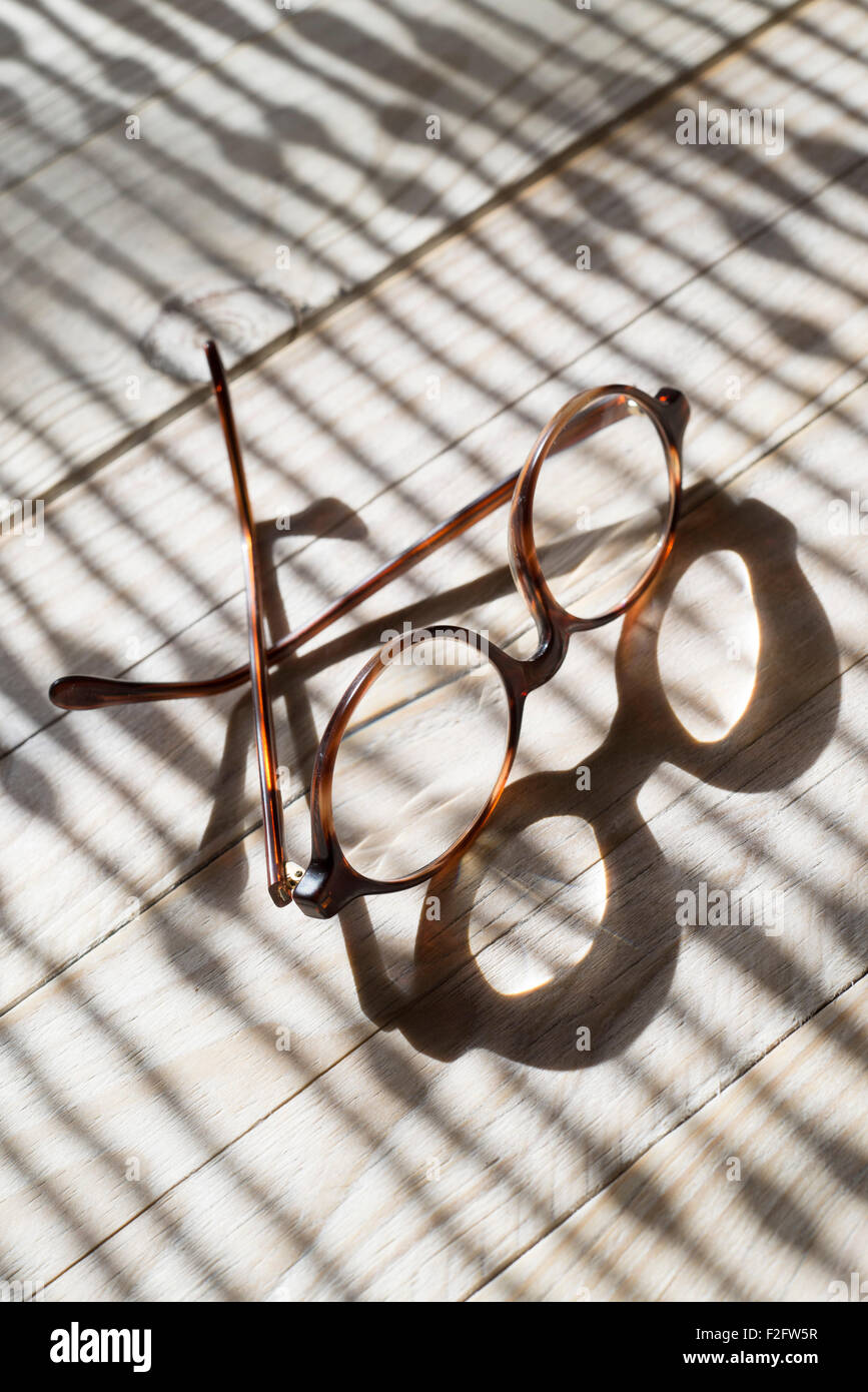 Clear Eyeglasses Glasses with Black Frame Fashion Vintage Style on Wood Desk Background, Rustic Still Life Style. Stock Photo