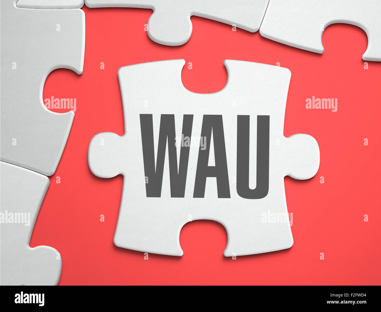 WAU - Weekly Active Users - Text on Puzzle on the Place of Missing Pieces. Scarlett Background. Close-up. 3d Illustration. Stock Photo
