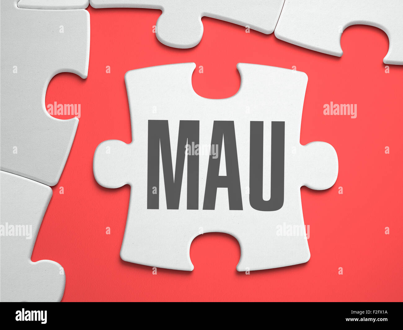 MAU - Monthly Active Users - Text on Puzzle on the Place of Missing Pieces. Scarlett Background. Close-up. 3d Illustration. Stock Photo