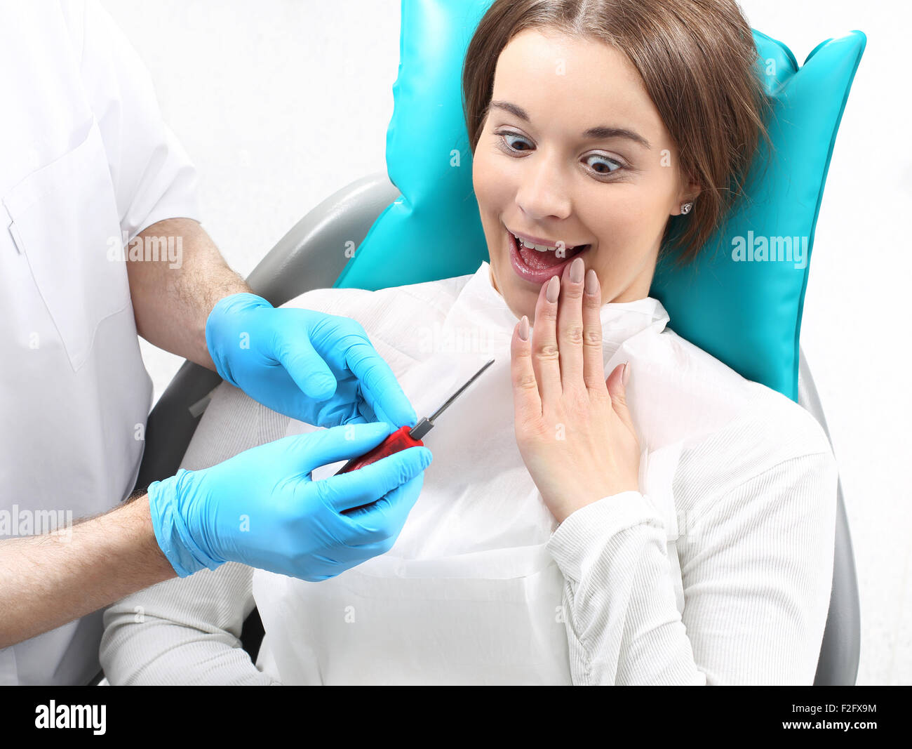 Frightened woman on a dentist's chair, fear of the dentist Stock Photo