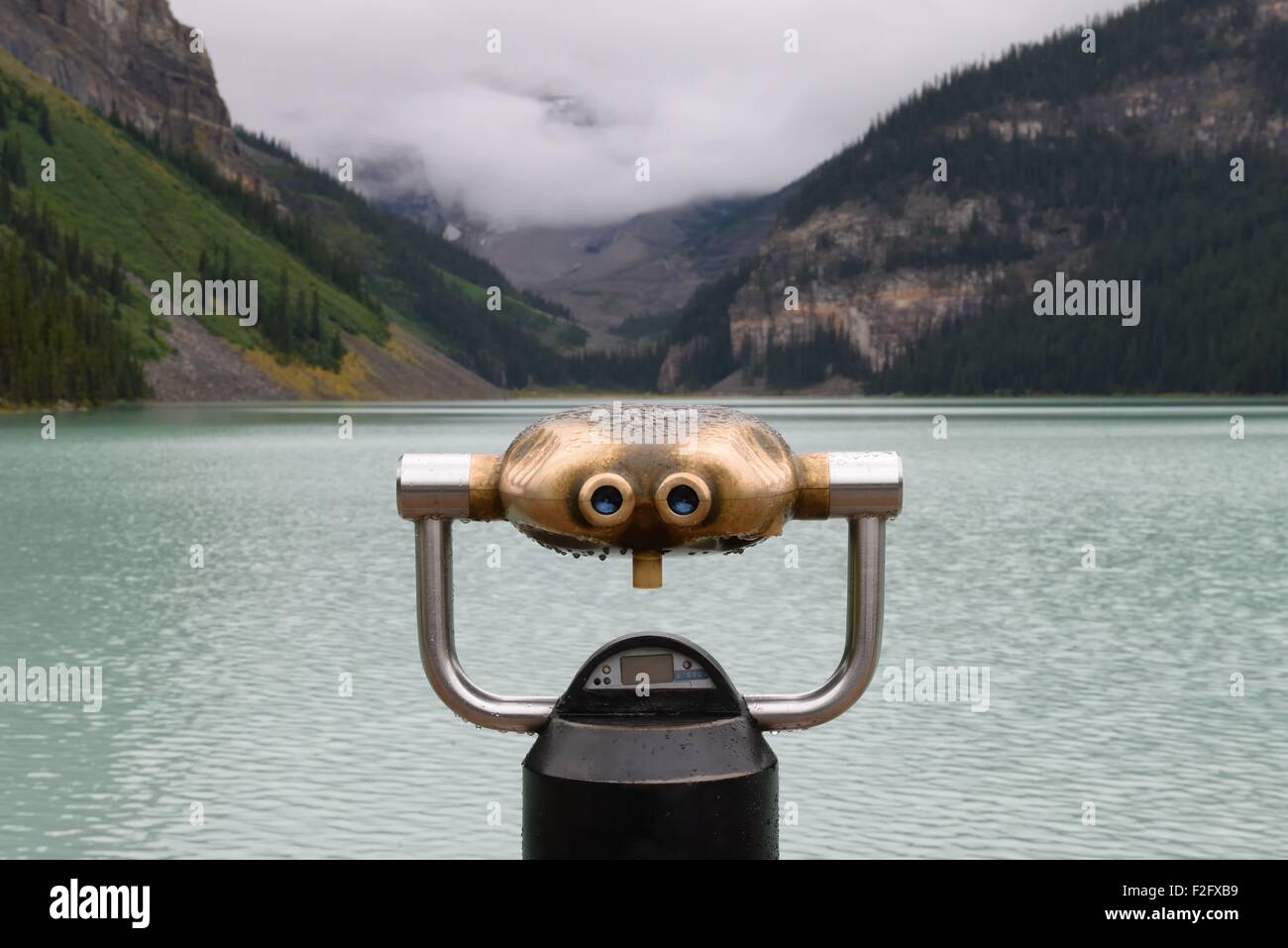 Face-like binoculars close-up overlooking the turquoise water of Lake Louise, Banff, Canada Stock Photo