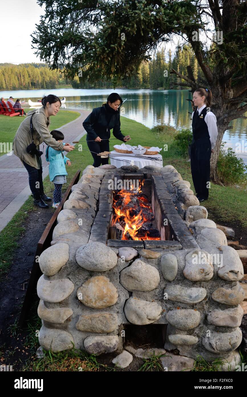 Toasting marshmallows over an open fire at the Jasper Park Lodge, Jasper, Alberta, Canada. Stock Photo