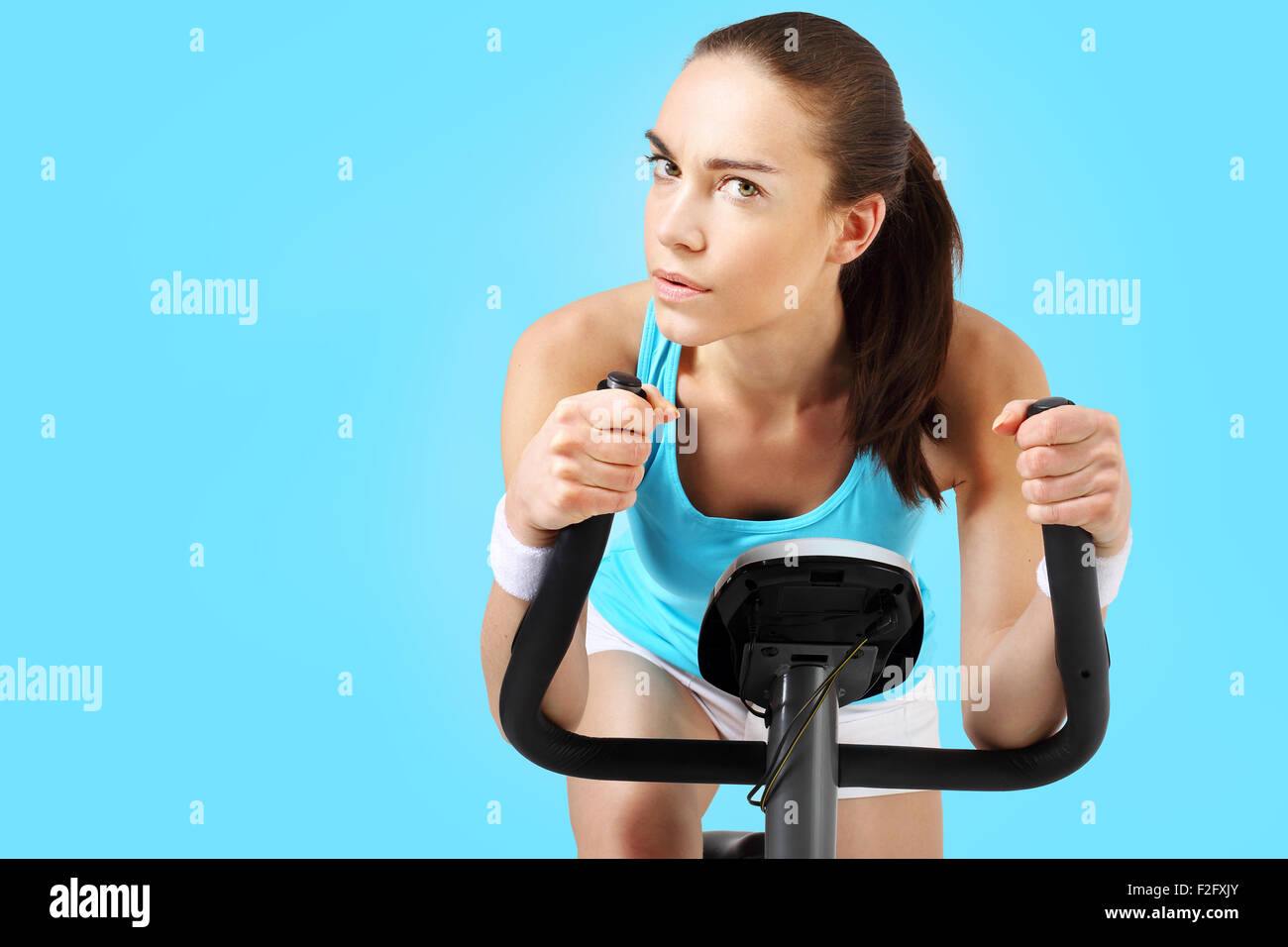 Spinning woman exercising on a stationary bike Stock Photo