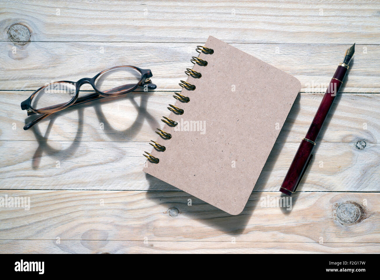 glasses, pen and notebook on wooden background Stock Photo