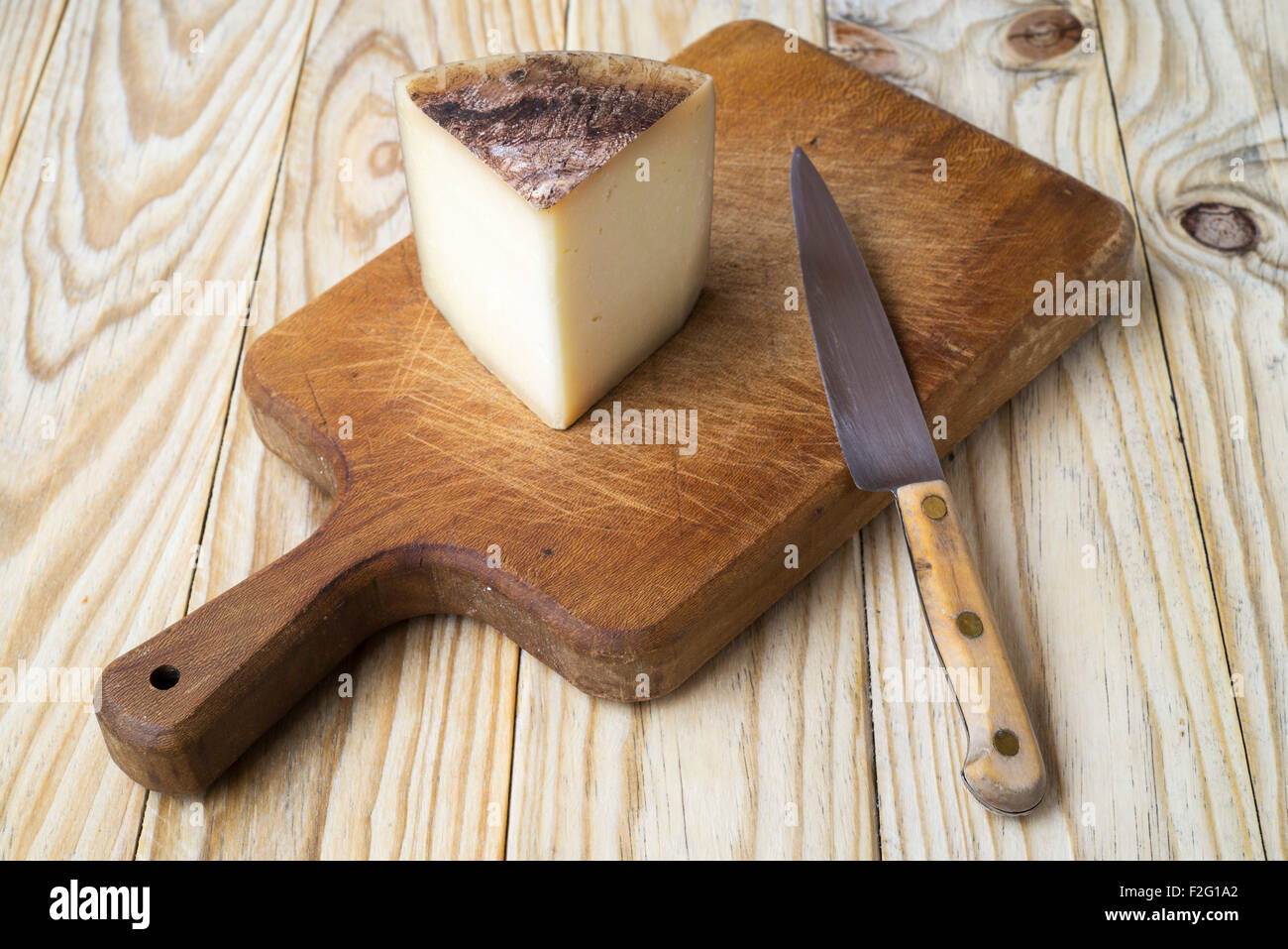 Cheese and knife on cutting board Stock Photo