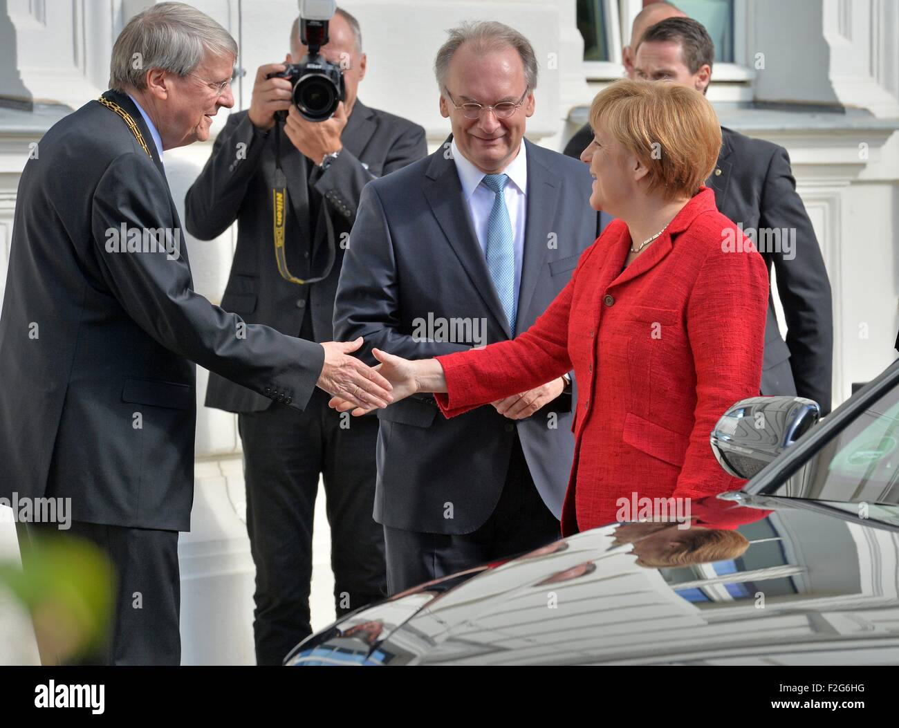 Halle, Germany. 18th Sep, 2015. The Premier of Saxony-Anhalt Reiner Haseloff (CDU, R) and the President of the Leopoldina German National Academy for Sciences, Joerg Hacker (L) greet German Chancellor (CDU) Angela Merkel at the beginning of the acadamy's annual meeting in Halle, Germany, 18 September 2015. The event this year is being held under the title 'Symmetry and asymmetry in science and art' Photo: HENDRIK SCHMIDT/DPA/Alamy Live News Stock Photo