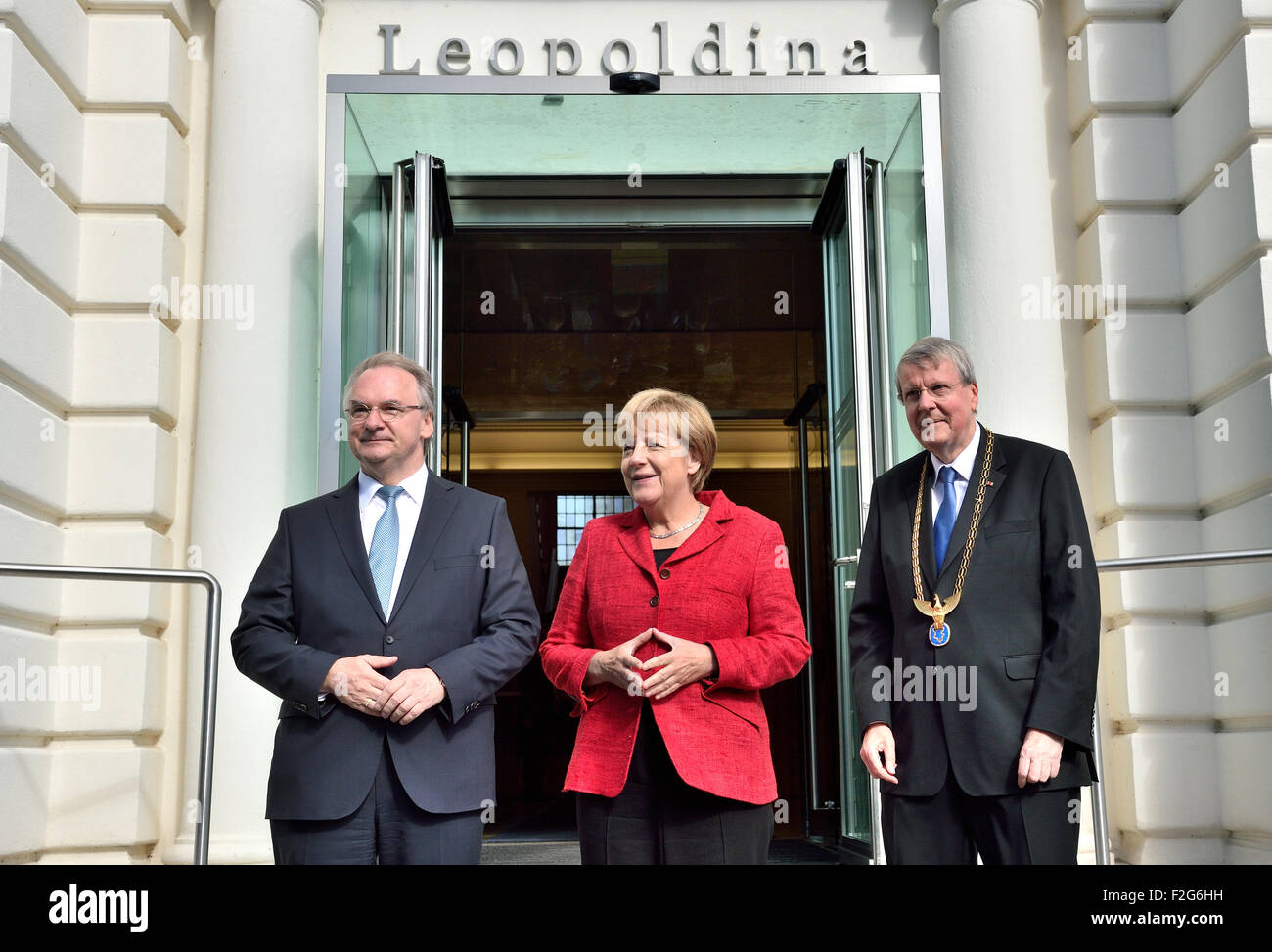 Halle, Germany. 18th Sep, 2015. The Premier of Saxony-Anhalt Reiner Haseloff (CDU, L) and the President of the Leopoldina German National Academy for Sciences, Joerg Hacker greet German Chancellor (CDU) Angela Merkel at the beginning of the acadamy's annual meeting in Halle, Germany, 18 September 2015. The event this year is being held under the title 'Symmetry and asymmetry in science and art' Photo: HENDRIK SCHMIDT/DPA/Alamy Live News Stock Photo