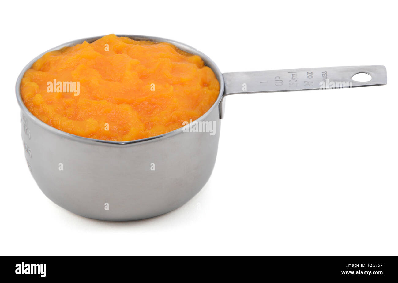 Pureed pumpkin in an American measuring cup, isolated on a white background Stock Photo