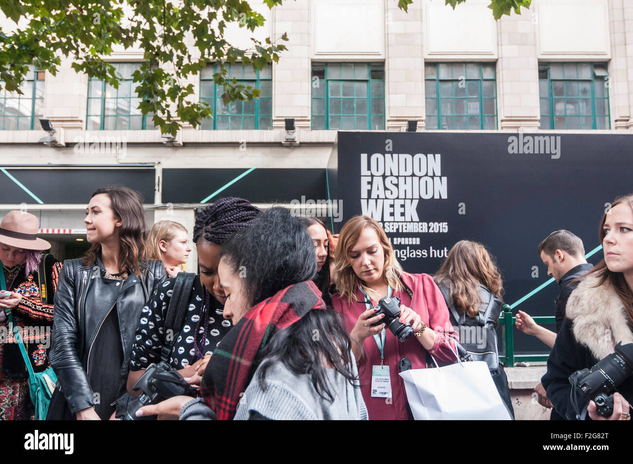 London, UK. 18 September 2015.  Fashionistas and followers of fashion gather at the new venue of Brewer Street Car Park in Soho for the launch of London Fashion Week.  Heavy rain showers did little to dampen their excitement. Credit:  Stephen Chung / Alamy Live News Stock Photo