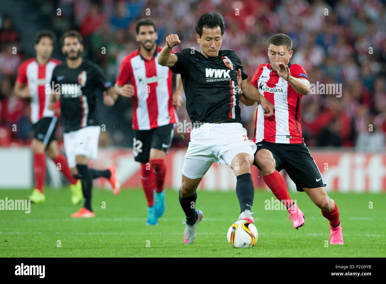 Bilbao, Spain. 17th Sep, 2015. Ji Dong-Won (L) of Augsburg and Oscar De Marcos of Bilbao vie for the ball during the UEFA Europa League Group L soccer match between Athletic Bilbao and FC Augsburg at Estadio de San Mames in Bilbao, Spain, 17 September 2015. Photo: Juan Flor/dpa/Alamy Live News Stock Photo