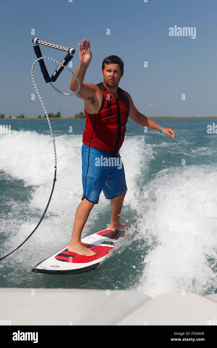 A man throwing the tow rope back to the boat while wakesurfing