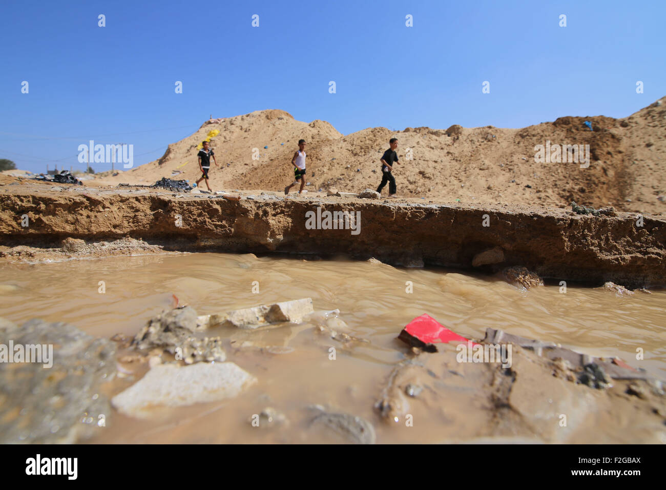 Gaza, Gaza Strip city of Rafah. 18th Sep, 2015. Palestinian children play in the water after Egyptian forces flooded smuggling tunnels dug beneath the Gaza-Egypt border, in the southern Gaza Strip city of Rafah, on Sept. 18, 2015. According to Palestinian witnesses, the Egyptian authorities pumped water from the Mediterranean Sea through pipes to destroy the tunnels. © Khaled Omar/Xinhua/Alamy Live News Stock Photo