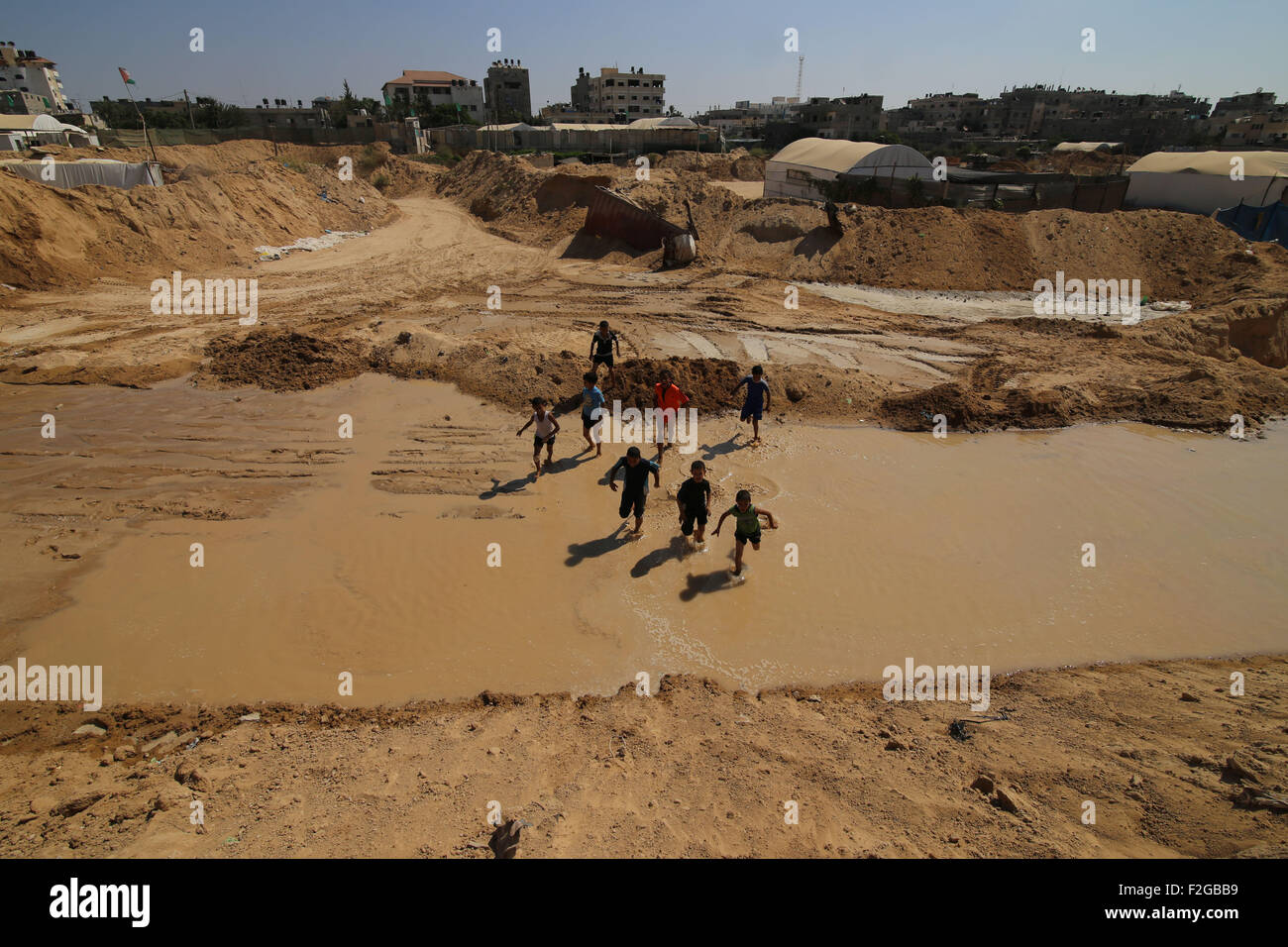 Gaza, Gaza Strip city of Rafah. 18th Sep, 2015. Palestinian children play in the water after Egyptian forces flooded smuggling tunnels dug beneath the Gaza-Egypt border, in the southern Gaza Strip city of Rafah, on Sept. 18, 2015. According to Palestinian witnesses, the Egyptian authorities pumped water from the Mediterranean Sea through pipes to destroy the tunnels. © Khaled Omar/Xinhua/Alamy Live News Stock Photo