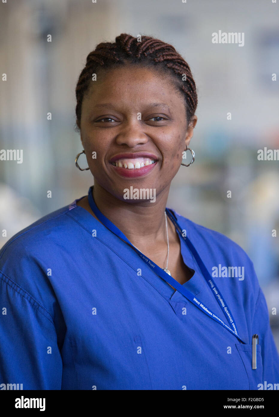 An NHS nurse smiling wearing scrubs Stock Photo