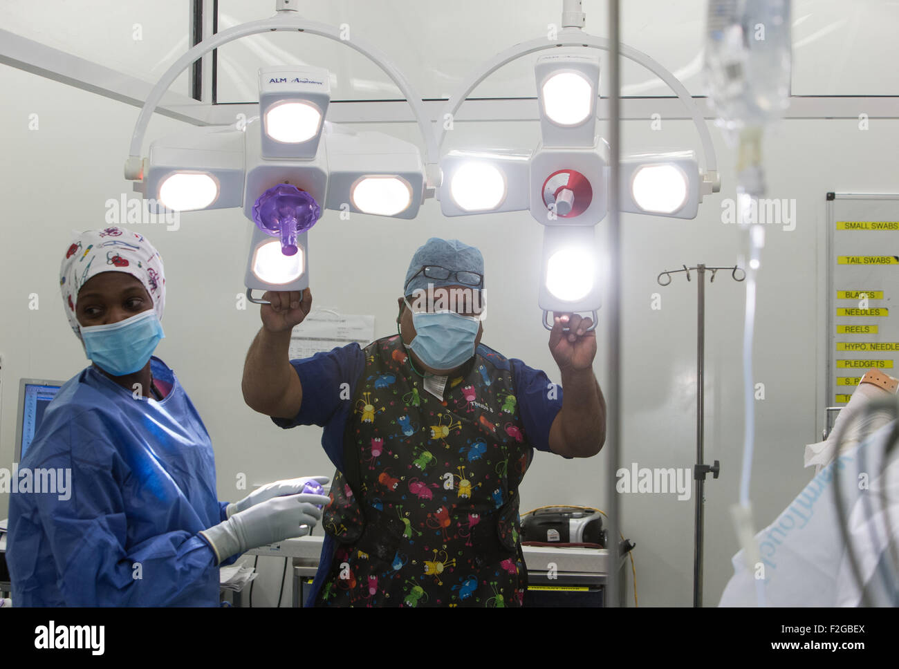 Surgeon and medical staff working in an operating theatre in an NHS hospital Stock Photo