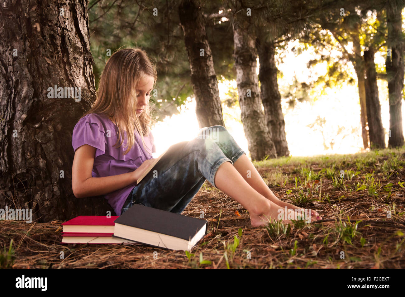 Girl escaping in woods  to read Stock Photo