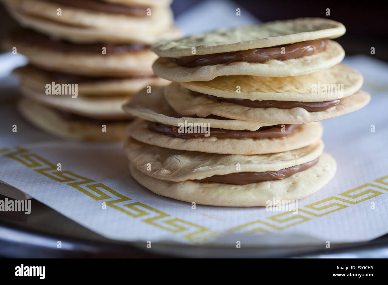 horizontal photo of two stacks of alfajore cookies on white paper Stock Photo