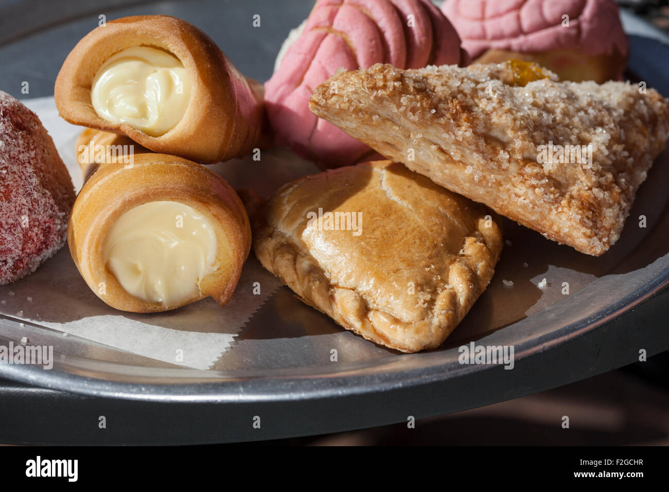 horizontal photo of various Mexican pastries on metal platter in bright sunlight Stock Photo